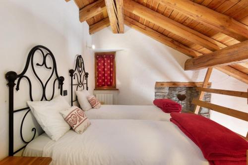 a bedroom with two beds in a room with wooden ceilings at Locanda delle Miniere in Ollomont