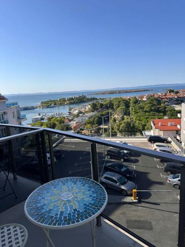 a table on a balcony with a view of a parking lot at Hotel Filland in Sozopol
