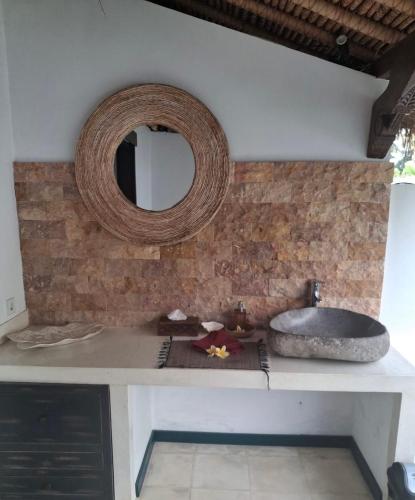 a bathroom counter with a sink and a mirror at Villa WHITE KAROUNA in Sukawati
