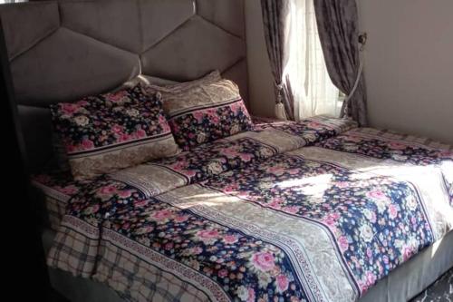 a large bed in a bedroom with a large headboard at Apartment Sleeps 4 with Balcony and Parking in Asaba