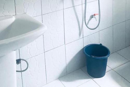 a bathroom with a blue trash can next to a sink at Apartment Sleeps 4 with Balcony and Parking in Asaba