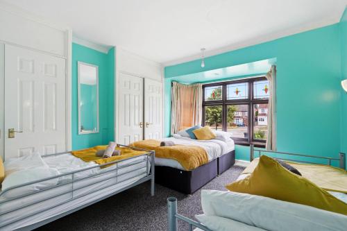 two beds in a room with blue walls at 4 Bedroom Central Birmingham in Birmingham