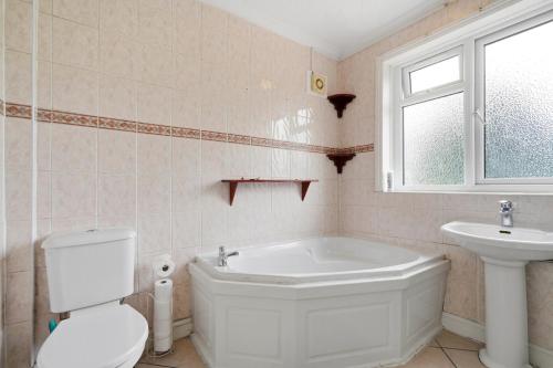 a bathroom with a tub and a toilet and a sink at 4 Bedroom Central Birmingham in Birmingham