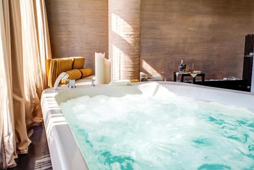 a bath tub filled with water in a bathroom at Hotel Le Palme - Premier Resort in Milano Marittima