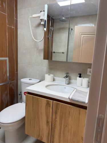 a bathroom with a sink and a toilet and a mirror at Azur Properties 72 in Shkorpilovtsi