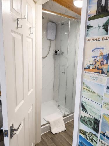 ein Badezimmer mit Dusche mit Glastür in der Unterkunft SherPai Lodge in Kent