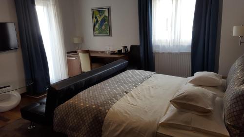 a bedroom with a bed and a desk and window at Residence Villa Karda in Poreč