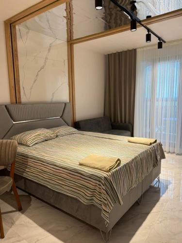 a large bed in a room with a chair at Azur Properties 56 in Shkorpilovtsi