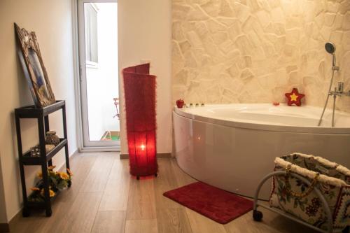 a bathroom with a white tub and a large window at Rosu in Triggiano