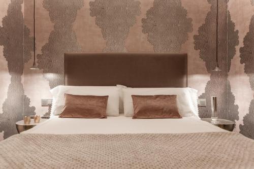 a bedroom with a large bed with white sheets and pillows at Villa Birdie Boutique - Adults Only in Donostia-San Sebastián