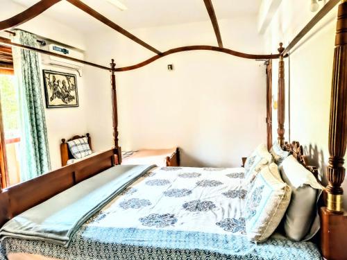 a bedroom with a canopy bed with a blue and white quilt at Ocean Breeze Apartment Colombo in Colombo