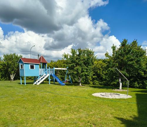 a playground with a house and a slide at Apartamenty Sokółka II in Sokółka
