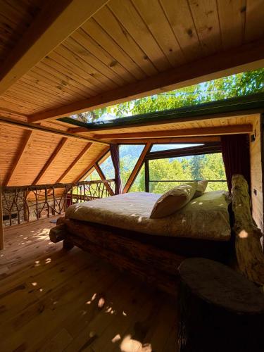 a bed in a wooden room with a roof at Riona dağ evleri in Çamlıhemşin