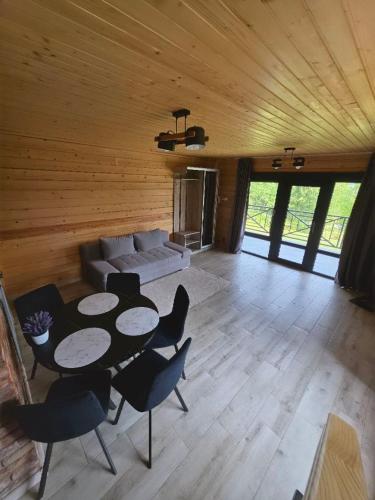 a living room with a couch and a table and chairs at Гірська Лаванда in Skhidnitsa