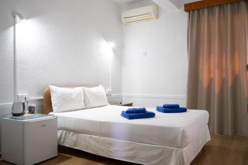 a bedroom with a bed with blue towels on it at Le Village Hotel in Limassol