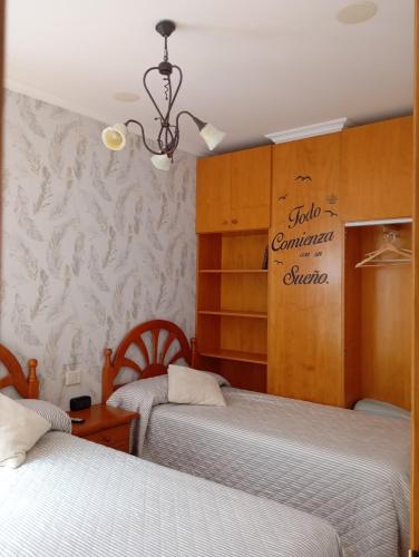 a bedroom with two beds and a sign on the wall at Casa Chus in Foz