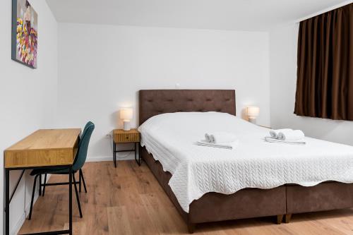 a bedroom with a bed and a desk and a table at Villa Bagulina in Drniš