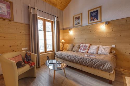 a bedroom with a bed and a chair and a table at Chez Philippe - Appartements et Chalets - Panoramic Village vue Glaciers in La Grave