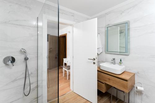 a white bathroom with a sink and a shower at Villa Bagulina in Drniš