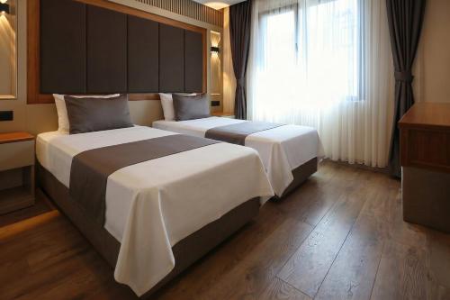 a hotel room with two beds and a window at Kalkan Hotel in Istanbul