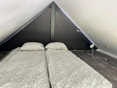 a bed with two pillows in a room at Ziemupes namiņš in Ziemupe