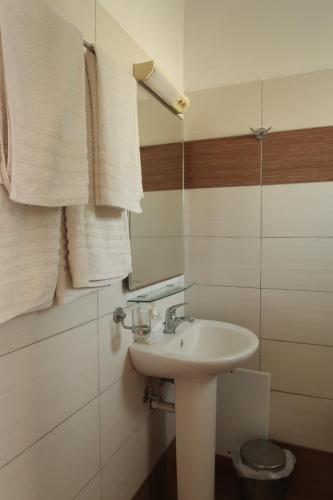 a bathroom with a sink and towels on the wall at Paraschos Studios Kos in Kardamaina