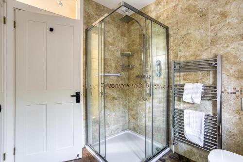 a shower with a glass door in a bathroom at Downclose Piggeries in North Perrott