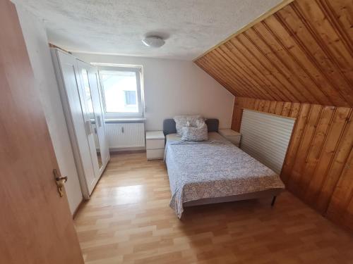 a small bedroom with a bed and a window at Vous êtes bienvenue in Ramstein-Miesenbach