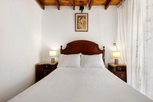 a bedroom with a bed with two nightstands and two lamps at Romantic Room - Charming Place in Provesende