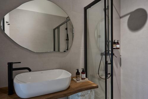 a bathroom with a sink and a mirror at Oikia Pouloudi in Kimolos