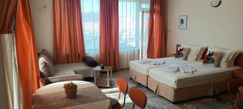 a hotel room with two beds and a table at Nirvana Guest House in Nesebar