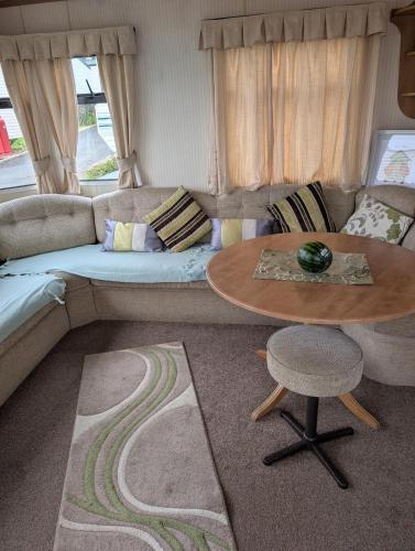 a living room with a couch and a table at Caravan 68 The Vale in Fishguard