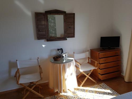a room with a table and two chairs and a television at Casa do Cabo de Santa Maria in Sagres