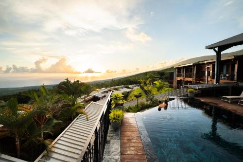 a resort swimming pool with a view of the ocean at Hôtel Diana Dea Lodge & SPA in Sainte-Anne-les Hauts