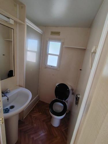 a bathroom with a black toilet and a sink at Camping Les Embruns N2 in Le Grau-dʼAgde