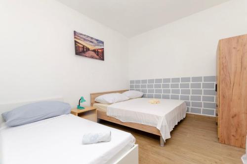 a room with two beds and a door in it at Apartments Kata in Grebaštica