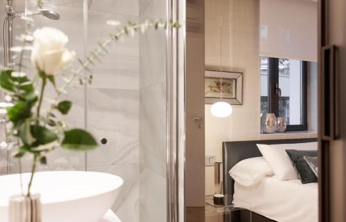 a bathroom with a shower and a sink and a bed at Villa Birdie Boutique - Adults Only in Donostia-San Sebastián