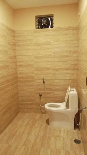 a bathroom with a white toilet in a room at Rock Retreat in Kanakapura