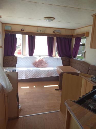 a small room with a bed in a rv at Sunrise Caravan in Dymchurch