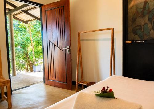 a room with a bed with a door and a mirror at Belihuloya Escape and Cafe in Belihuloya