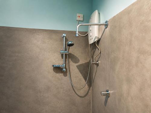 a shower in a bathroom with a shower head at Belihuloya Escape and Cafe in Belihuloya