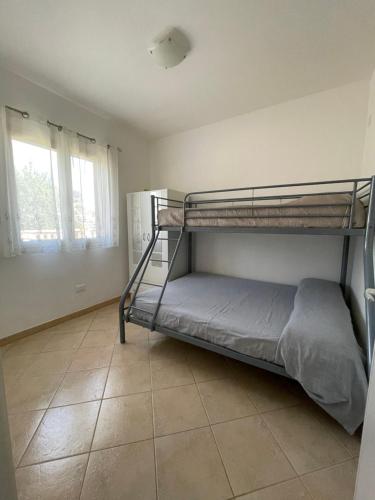 a bedroom with two bunk beds and a tile floor at Villetta PEPE nel Salento in Salve