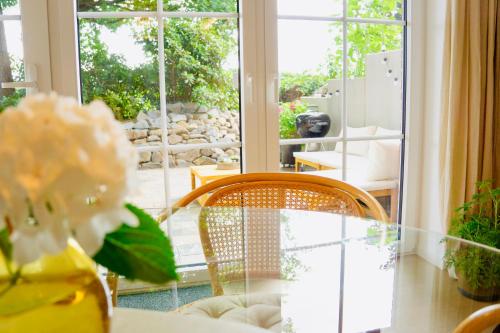 a table with a vase with a flower and a window at Boutique Home Bad Iburg in Bad Iburg