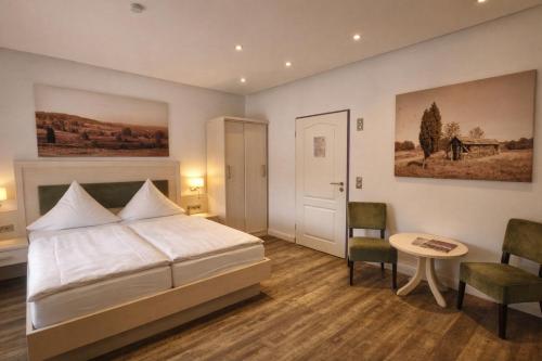 a bedroom with a bed and a table and chairs at Egestorfer Hof in Egestorf