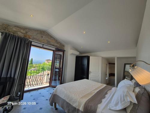 a bedroom with a bed and a large window at Villa Arca in Les Arcs sur Argens