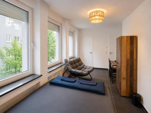 a living room with a chair and a window at Hotelikum zentreal Bequem in Heilbronn