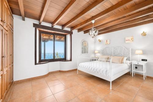 a bedroom with a white bed and a window at LAS MORADITAS, CHALET con PISCINA PRIVADA in Adeje