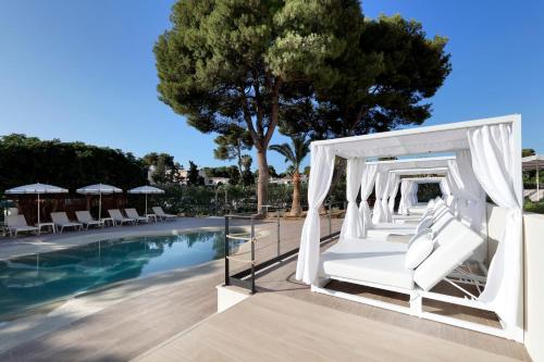 a white gazebo by the pool at a resort at Alua Linda Mallorca - Newly Renovated 2026 in Can Pastilla