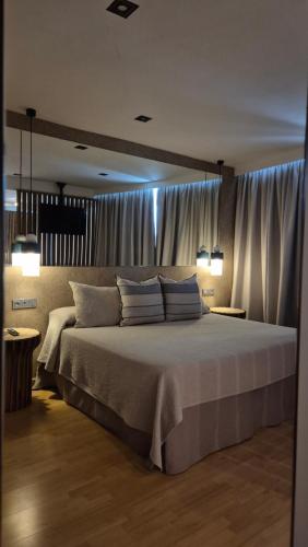 a bedroom with a large bed with white pillows at Hotel El Cruce Moraleda in Moraleda de Zafayona