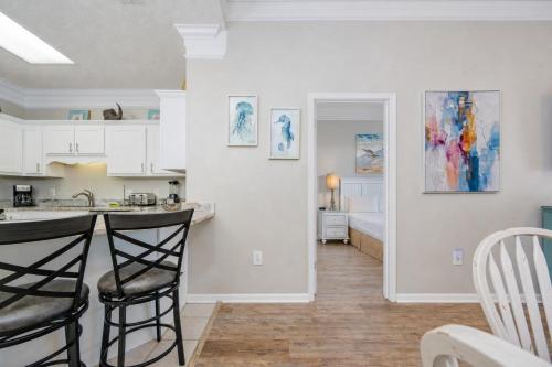 a kitchen and living room with two bar stools at Phoenix VI 6104 in Orange Beach